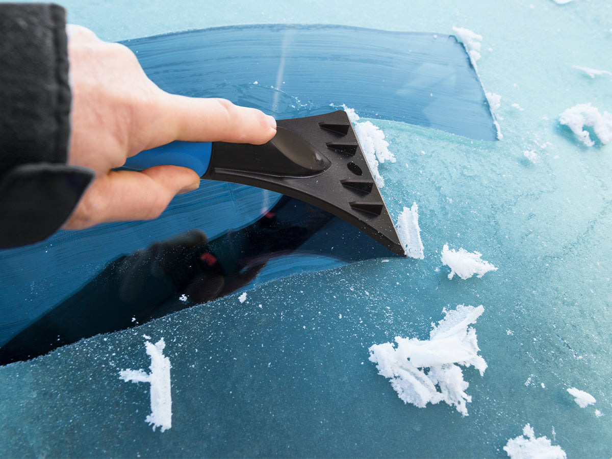 Eiskratzer kratzt Frost von der Autoscheibe