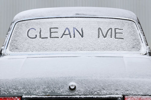 Zugeschneites Fahrzeug mit der Aufschrift "Clean Me" auf der Rückscheibe
