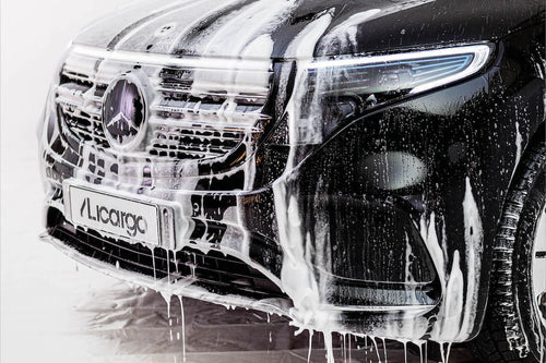 Snow Foam wird mit Wasser von einem Auto abgewaschen